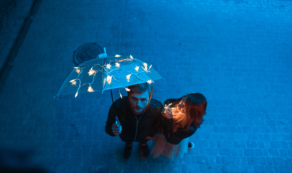 Guy and girl are looking at the camera on the night street